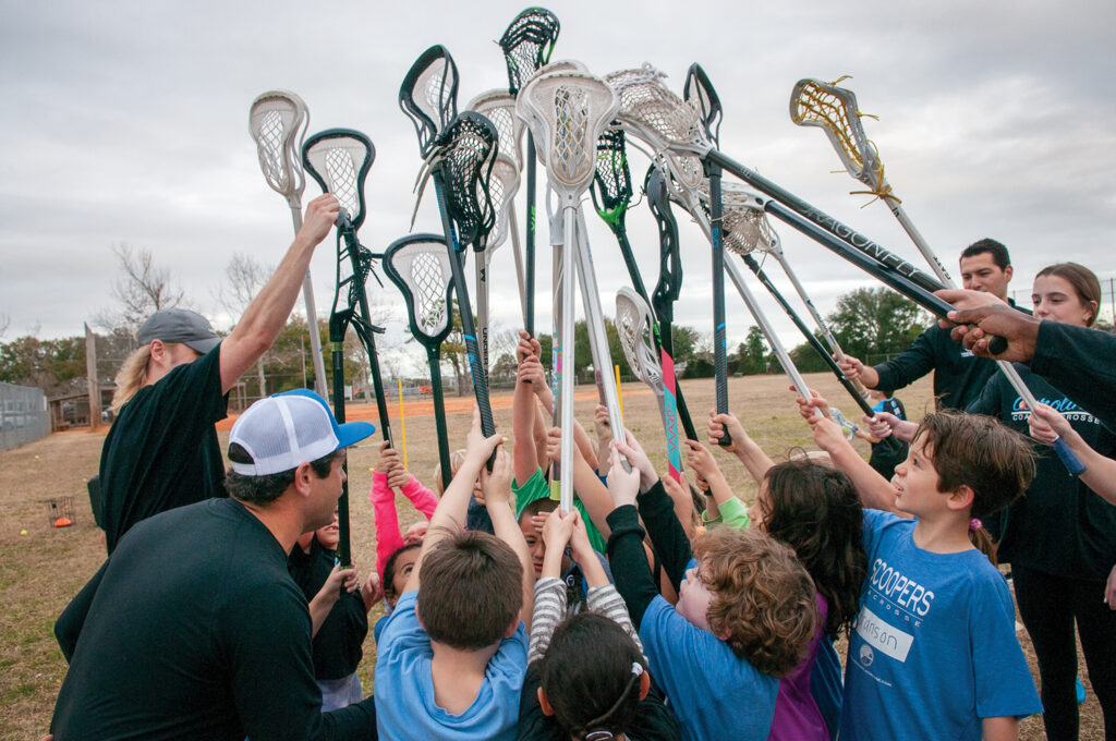 The Scoopers lacrosse players huddle at the end of practice in Wrightsville Beach Park on Feb. 3, 2022.  Photo by Allison Potter