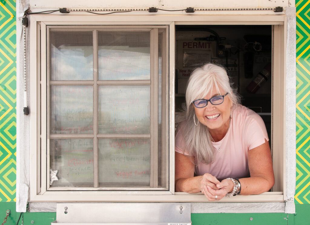Pat Bradford is seen aboard Pepe’s Taco Truck at Eagle Island Fruit and Seafood Market,
off Hwy. 421 across the Cape Fear River. Pepe has been in business close to 10 years and
is among the rotating food trucks that set up at Eagle Island. A fan of non-traditional
venues, Pat often seeks out street food vendors before haute cuisine. Pat’s Hair by Frank Potter, styled by Mason Chandler, makeup by Regan Daughtry. All from Bangz Hair Salon. Photo by Allison Potter