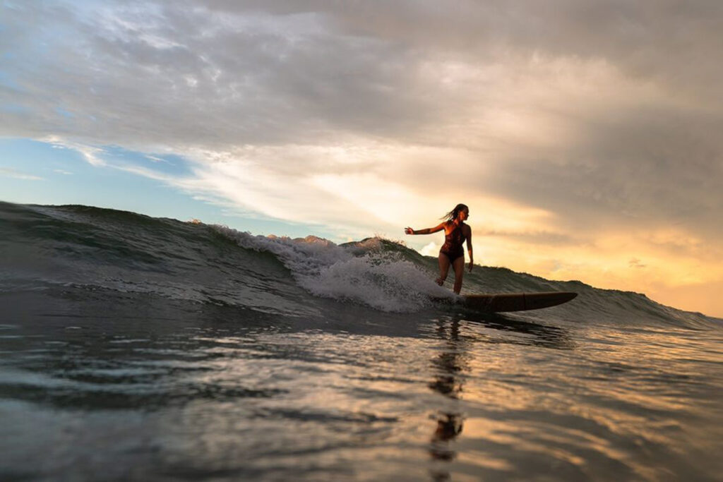 Laurel Senick surfing Wrightsville Beach on the north side of Crystal Pier at sunrise. Bryanna Lynn Pryce