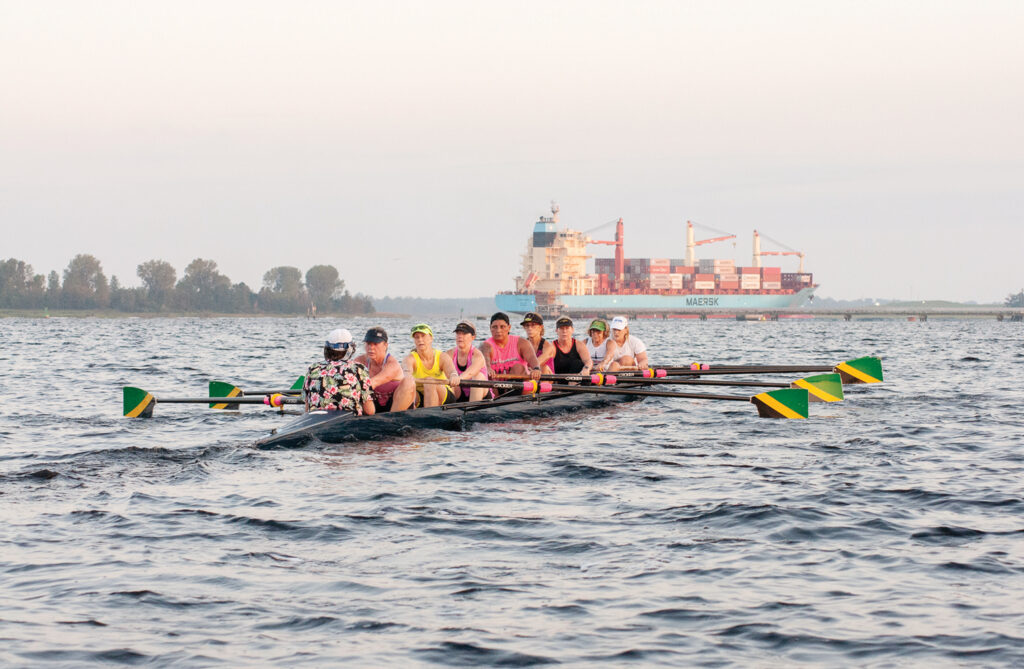 The women’s eight representing Cape Fear River Rowing Club at the Head of the Charles Regatta practices on the river as a container ship heads toward the Port of Wilmington in September. Allison Potter